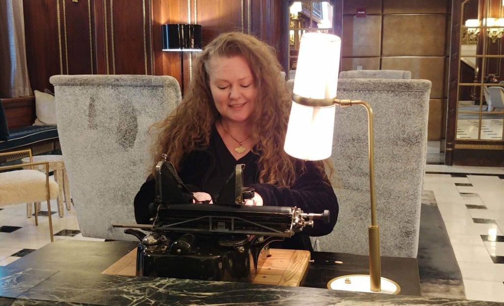 Theresa typing on an old Oliver typewriter in the lobby of the historic Blackstone.